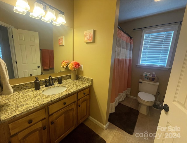 bathroom with toilet, vanity, tile patterned floors, and curtained shower