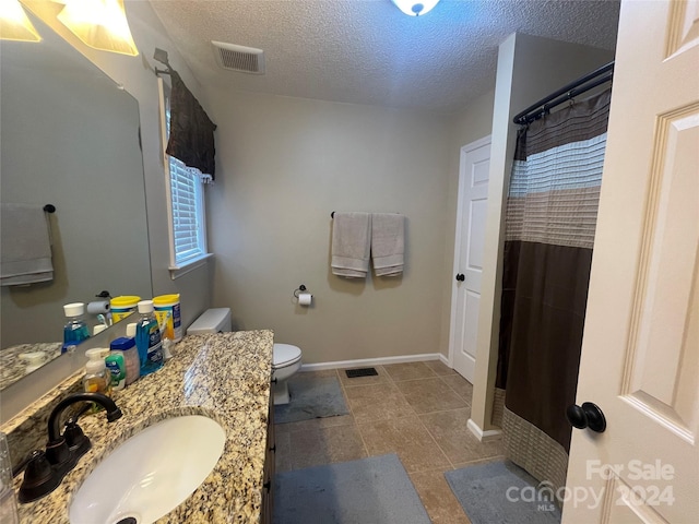 bathroom with a textured ceiling, toilet, a shower with curtain, and vanity