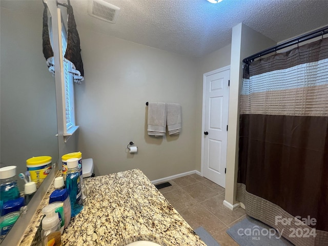 bathroom with a textured ceiling, toilet, a shower with shower curtain, and vanity