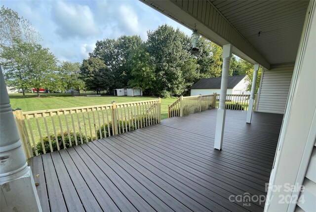 wooden deck featuring a shed and a yard