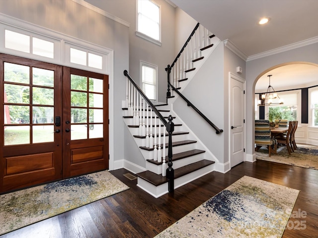 entryway featuring crown molding, dark hardwood / wood-style floors, a chandelier, and french doors