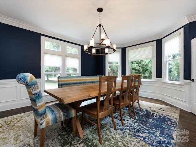 dining area with crown molding, dark wood-type flooring, and a notable chandelier