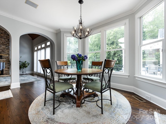 dining room with ornamental molding, dark hardwood / wood-style floors, and a chandelier