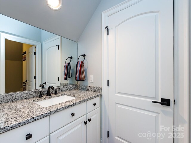 bathroom with vanity and vaulted ceiling