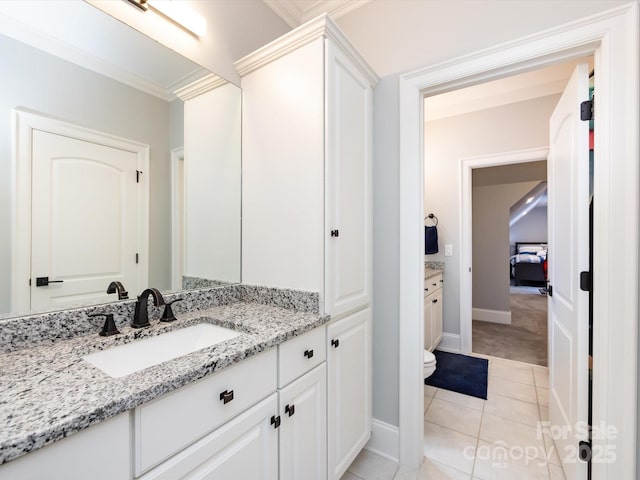 bathroom featuring tile patterned flooring, vanity, crown molding, and toilet