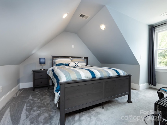 bedroom featuring lofted ceiling and carpet