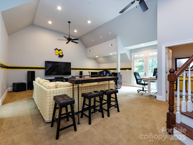 living room with ceiling fan, high vaulted ceiling, and light carpet