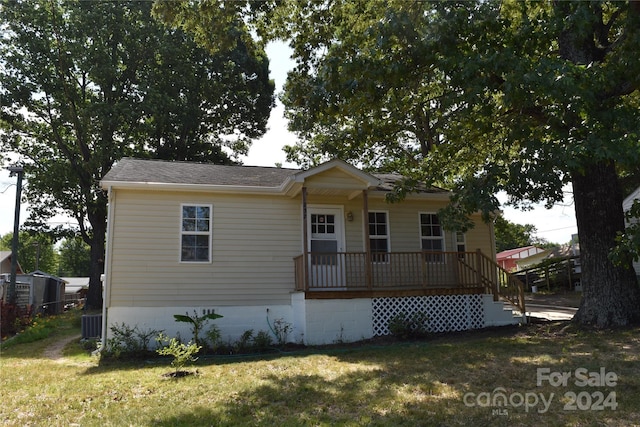 view of front of house with cooling unit and a front yard