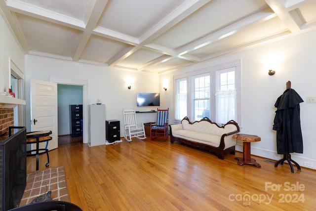 living room featuring hardwood / wood-style floors, beam ceiling, ornamental molding, and coffered ceiling