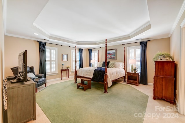 bedroom featuring light colored carpet, crown molding, and a tray ceiling