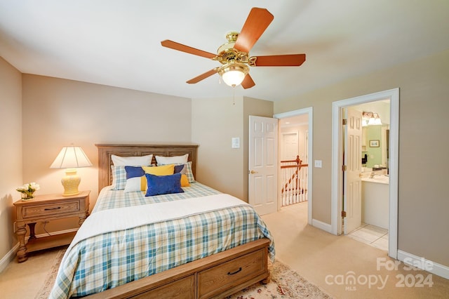 carpeted bedroom with ensuite bath and ceiling fan