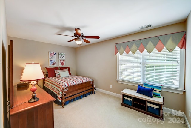 carpeted bedroom with ceiling fan and multiple windows