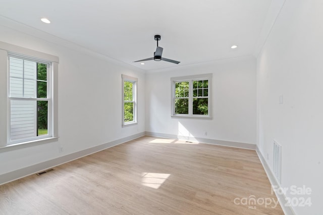 empty room featuring light wood-type flooring, ceiling fan, and crown molding