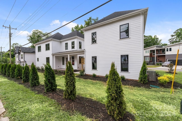 view of front of home featuring central AC, covered porch, and a front yard