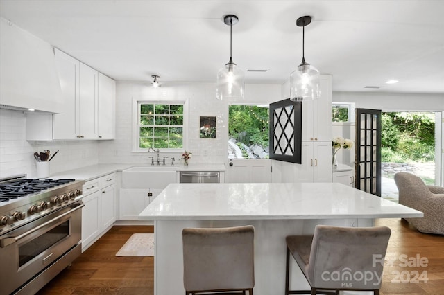 kitchen featuring stainless steel appliances, hanging light fixtures, and white cabinets