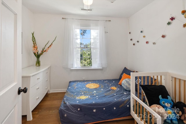 bedroom with dark hardwood / wood-style floors