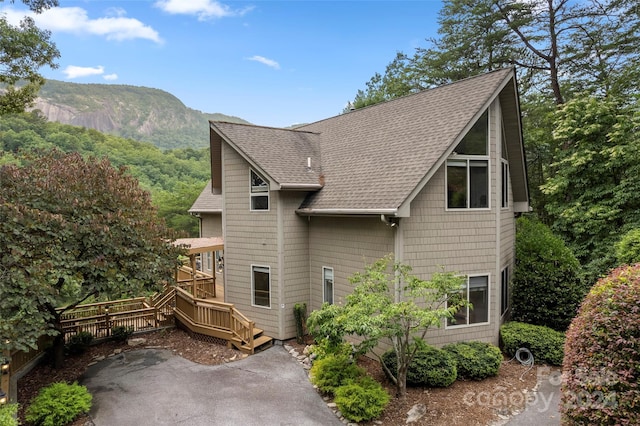 back of property with a deck with mountain view