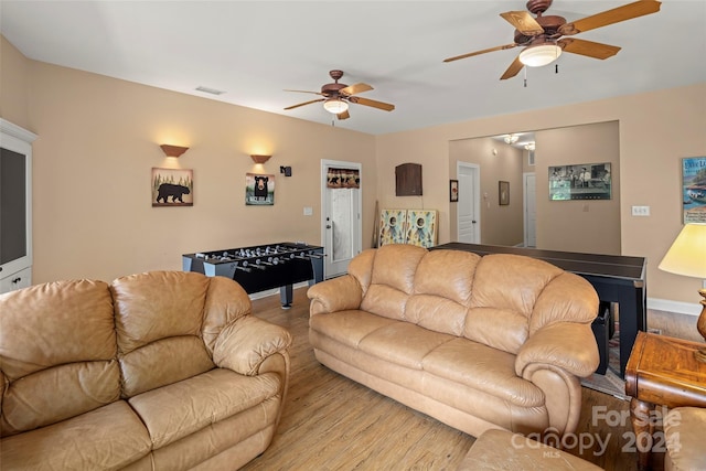 living room featuring ceiling fan and light hardwood / wood-style flooring