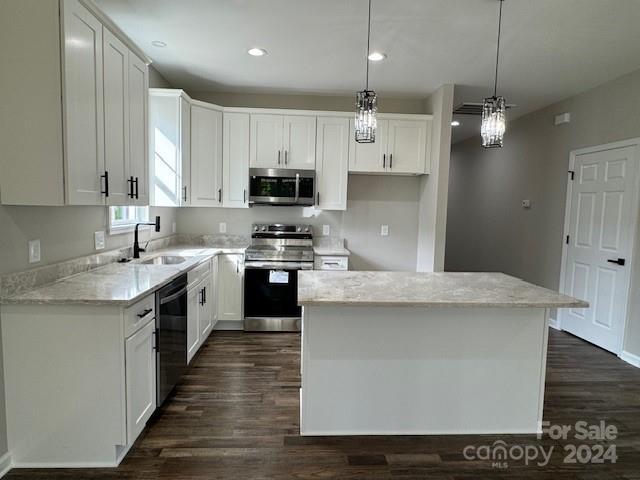 kitchen featuring a kitchen island, sink, hanging light fixtures, stainless steel appliances, and white cabinets