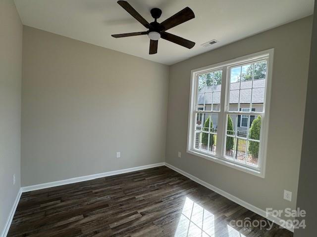 spare room with ceiling fan and dark hardwood / wood-style floors