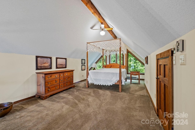 carpeted bedroom with a textured ceiling, lofted ceiling with beams, and a barn door