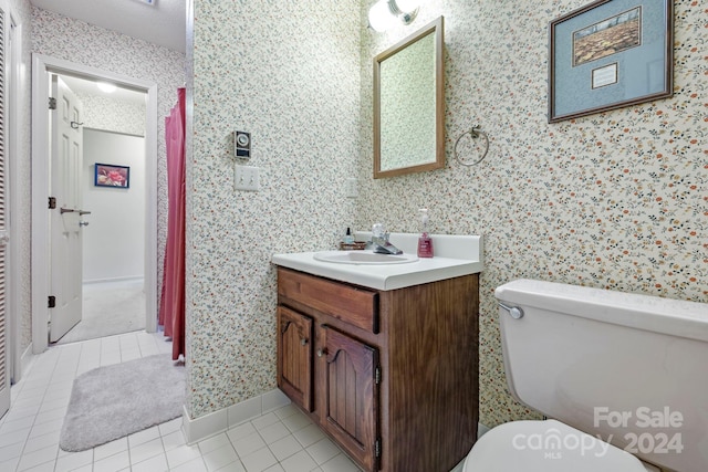 bathroom with tile patterned flooring, toilet, a textured ceiling, and vanity