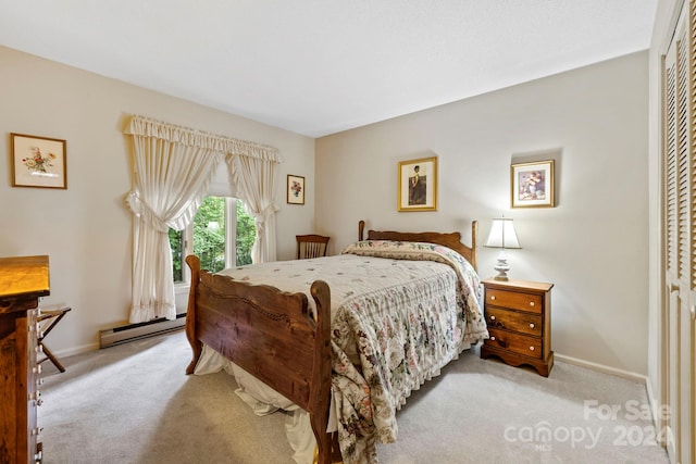 bedroom with a closet, a baseboard radiator, and light carpet