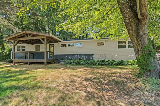 view of front of property featuring a deck and a front yard