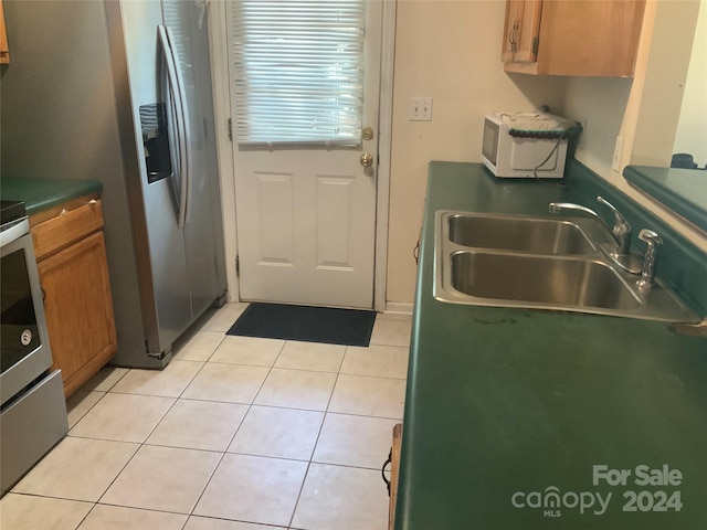 kitchen with light tile patterned flooring, stainless steel appliances, and sink