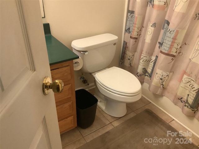 full bathroom with tile patterned floors, shower / bathtub combination with curtain, vanity, and toilet