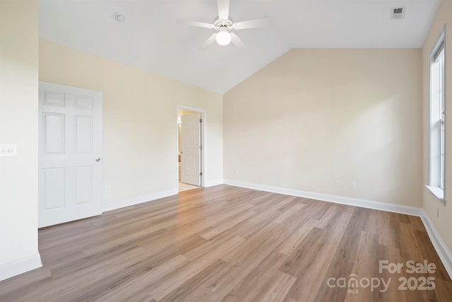 empty room featuring ceiling fan, light hardwood / wood-style flooring, plenty of natural light, and vaulted ceiling