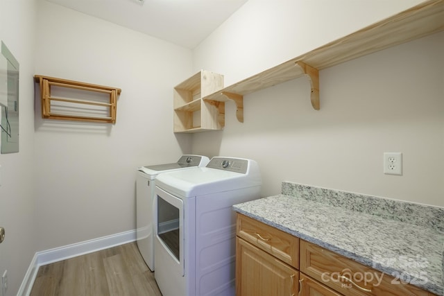 washroom featuring washing machine and clothes dryer and light hardwood / wood-style flooring