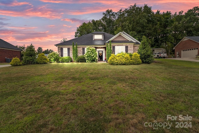 view of front of house with a garage and a lawn