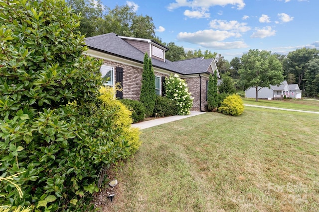 view of side of home with a yard