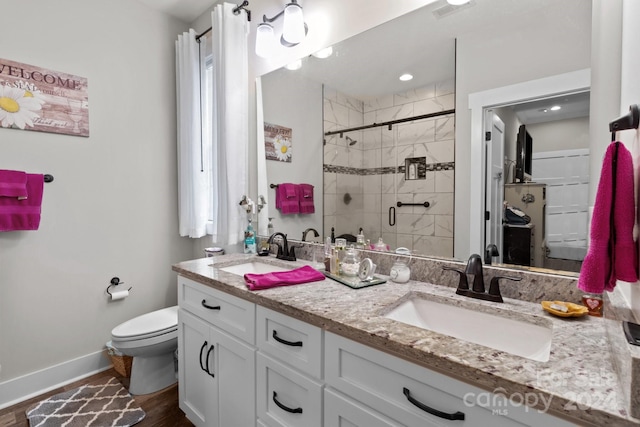 bathroom featuring hardwood / wood-style flooring, toilet, a shower with door, and vanity