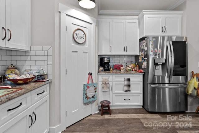 kitchen featuring light stone countertops, white cabinets, tasteful backsplash, stainless steel fridge with ice dispenser, and crown molding