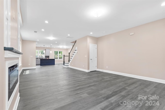 unfurnished living room with sink and wood-type flooring