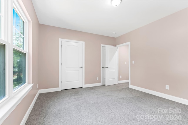 unfurnished bedroom with light carpet and multiple windows