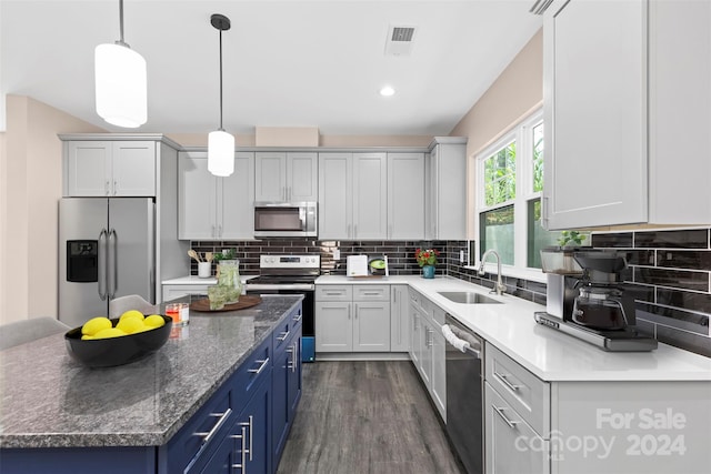 kitchen with stainless steel appliances, sink, a kitchen island, blue cabinets, and dark hardwood / wood-style flooring