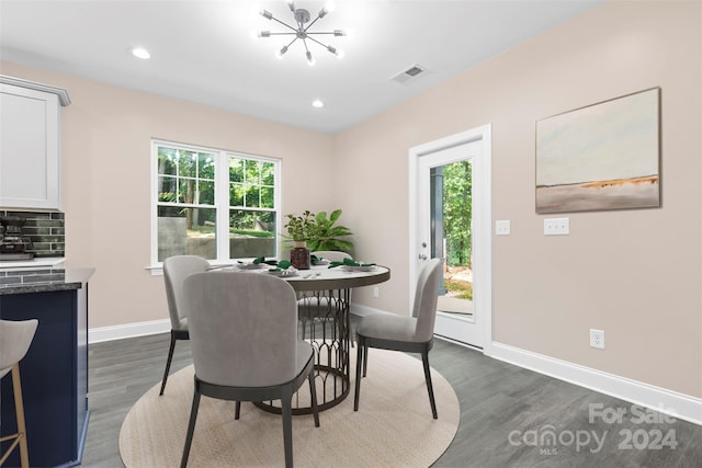 dining area featuring dark wood-type flooring and a chandelier