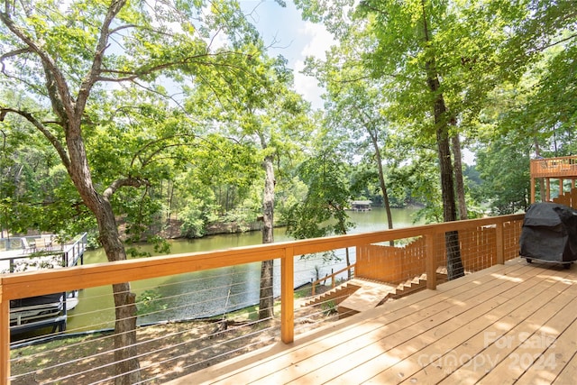 deck with a water view and a grill