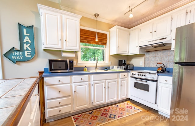 kitchen with white cabinets, decorative light fixtures, stainless steel appliances, sink, and tile countertops