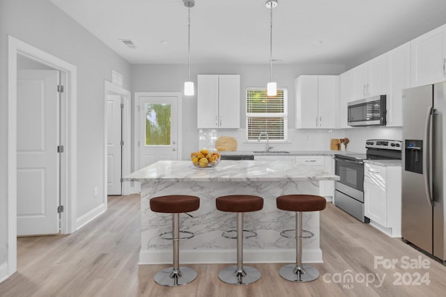 kitchen with a healthy amount of sunlight, stainless steel appliances, and light hardwood / wood-style floors