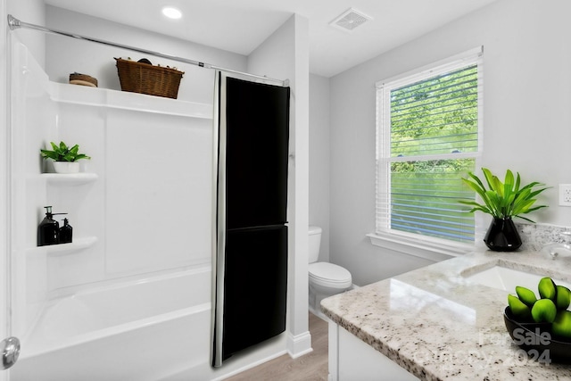 full bathroom with vanity, shower / bath combination, hardwood / wood-style flooring, and toilet