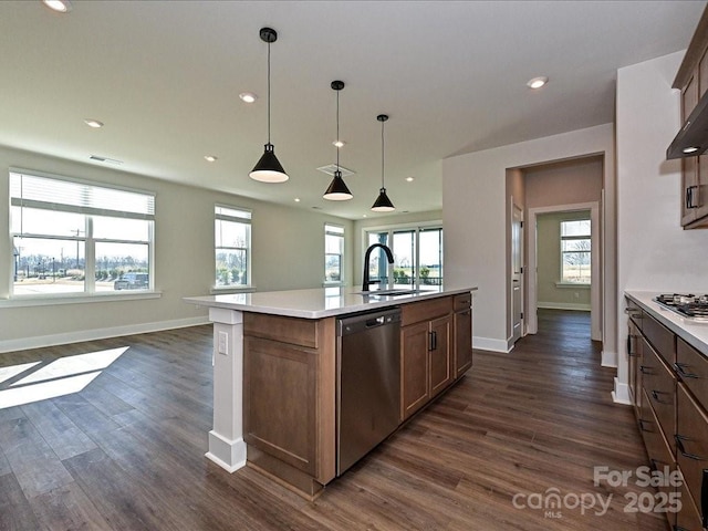 kitchen featuring a sink, stainless steel appliances, dark wood-style floors, and light countertops