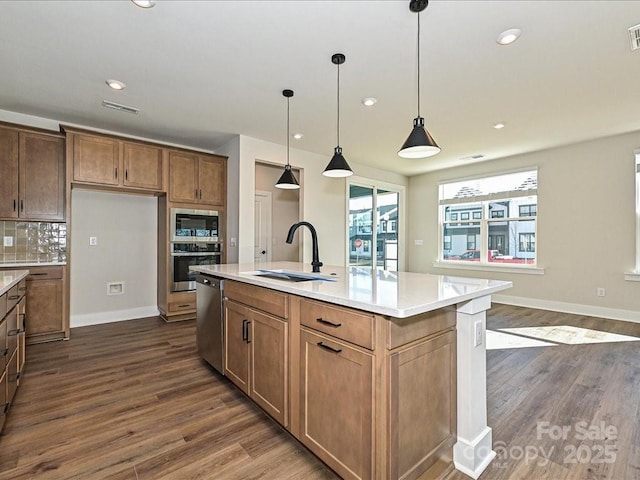 kitchen with visible vents, dark wood-type flooring, light countertops, appliances with stainless steel finishes, and a sink