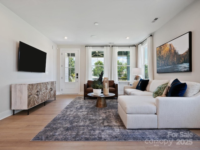 living room with visible vents, recessed lighting, wood finished floors, and baseboards
