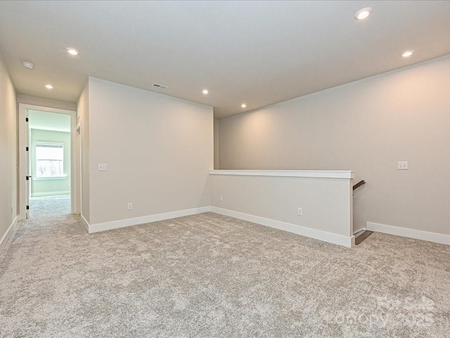 empty room featuring recessed lighting, light colored carpet, and visible vents