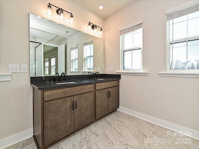bathroom featuring double vanity, visible vents, baseboards, and a sink