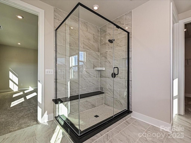 bathroom featuring baseboards, marble finish floor, and a shower stall